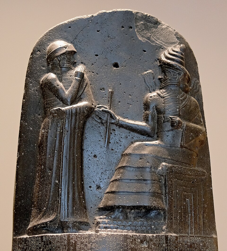 Schamasch, sitzend, mit Strahlen aus den Schultern, übergibt Hammurapi Ring und Stab — Spitze der Gesetzesstele, um 1750 v. Chr., Louvre
